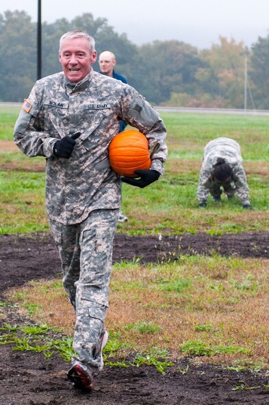 HANSCOM AIR FORCE BASE, Mass. – A team comprised of (left to right) U.S. Marines Maj. Josh Phares, Staff Sgt. Tim Bos, Capt. Ian Garvey and Air Force Senior Airman Omar Hay cheer after tossing a pumpkin off the third floor of the fire training facility and hitting a bulls eye on top of a vehicle's roof Oct. 10 during a Warrior Day obstacle. In addition to Airmen, teams from other services were invited to compete in the monthly event. (U.S. Air Force photo by Rick Berry)