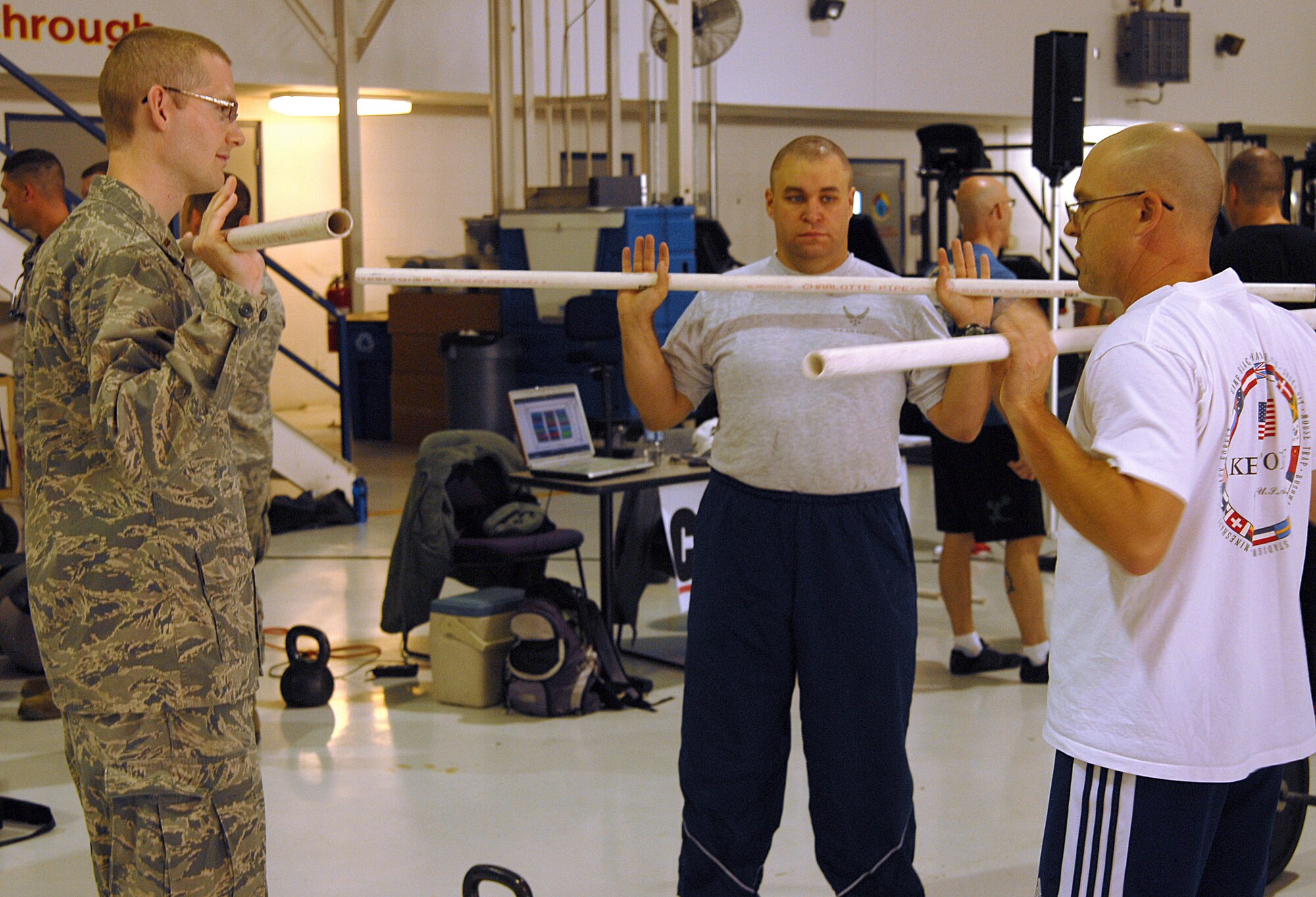 Maj. John Matuszak (r) a Cross Fit specialist, instructs 2nd Lt. Matthew Janson and Airman 1st Class Jeffrey Rhodes on a cross fit exercise at Springfield Air National Guard Base, Ohio October 13, 2012.  Matuszak was training Janson and Rhodes in Cross Fit as part of the 178th Fighter Wing fitness expo that was taking place at the base. (US Air Force Photographer MSgt Seth Skidmore/released)
