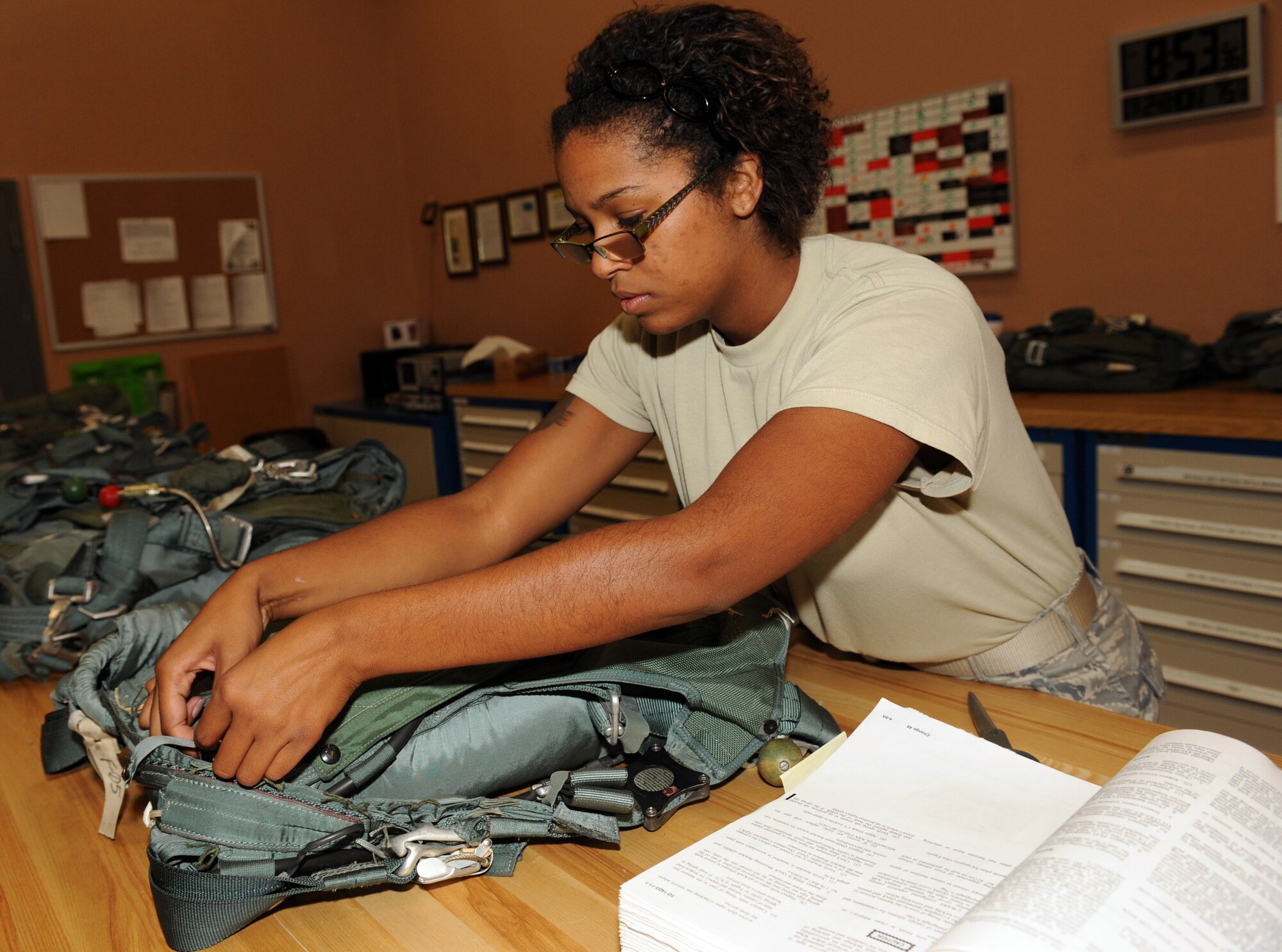 U.S. Air Force Senior Airman Aradonis Perry, 563rd Operations Support Squadron aircrew flight equipment technician, fastens a strap on the back style automatic-18 during a 30-day inspection on Davis-Monthan Air Force Base, Ariz., Sept. 24, 2012. Each parachute is inspected for proper functionality by an aircrew flight equipment technician and then quality checked before being loaded onto an aircraft. (U.S. Air Force photo by Senior Airman Timothy Moore/Released)