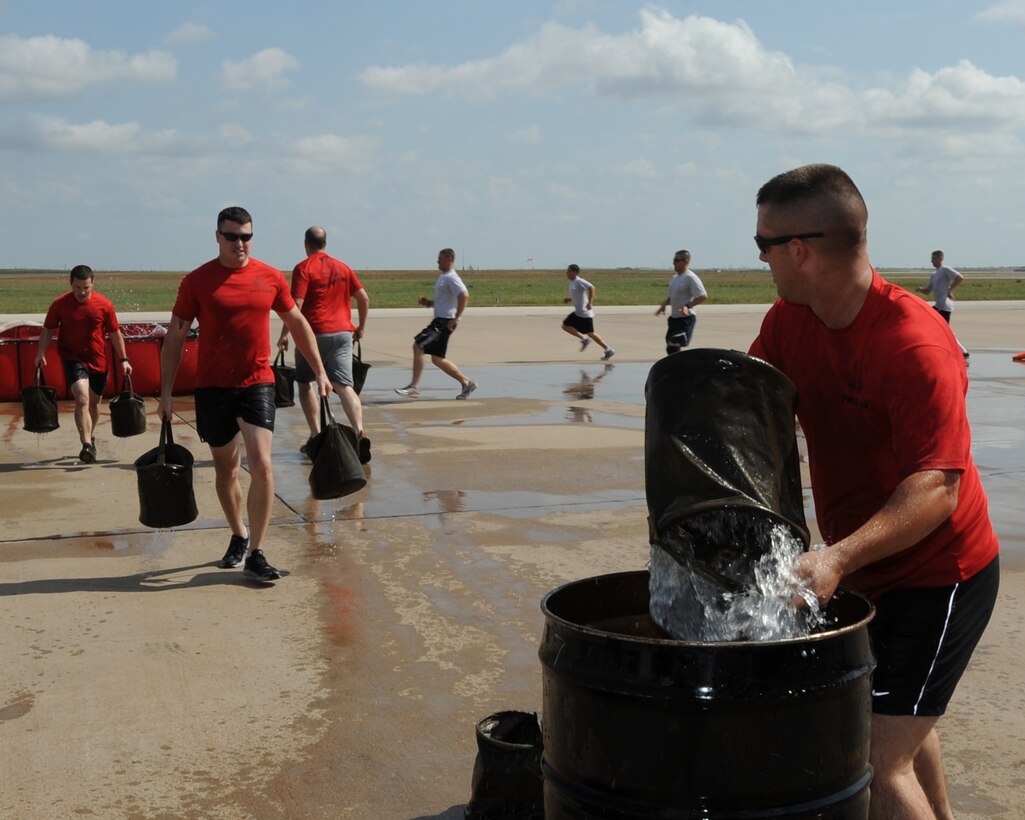 EOD Preliminary School instructors from the 366th Training Squadron participate in the bucket brigade event Oct. 12, 2012, at the 3rd annual Fire Prevention Olympics. The event was hosted by the Sheppard Air Force Base fire department as part of Fire Prevention week.  (US Air Force photo/Felton Joshua Jr.)