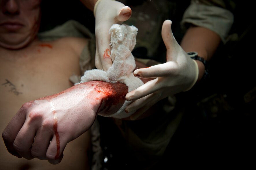 A pararescueman from the 38th Rescue Squadron performs simulated medical procedures at Moody Air Force Base, Ga., Oct. 5, 2012. The pararescuman wrapped the patient’s wound and attempted to stop the bleeding. (U.S. Air Force photo by Senior Airman Douglas Ellis/Released)
