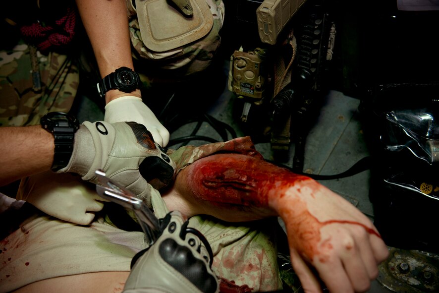 U.S. Air Force pararesuemen from the 38th Rescue Squadron perform simulated medical procedures at Moody Air Force Base, Ga., Oct. 5, 2012. The Airmen removed some of the patient’s clothing to properly treat the wounds. (U.S. Air Force photo by Senior Airman Douglas Ellis/Released)
