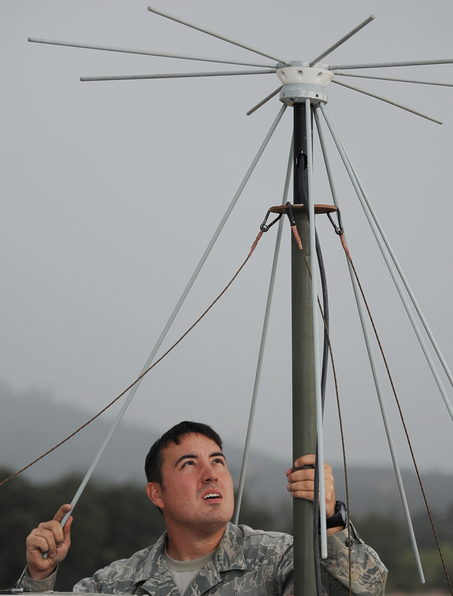 Staff Sgt. Sean Sawyer, assigned to the 573rd Global Support Squadron, prepares to dissemble a UHF/VHF antenna during inclement weather, at the U.S. Army Combat Support Training Center at Fort Hunter Liggett, Calif. during Exercise Soaring Angel.  Members of the 621st Contingency Response Wing and the 129th Rescue Wing, partnered to get crucial training at the installation’s Schoonover LZ. (U.S. Air Force Photo/MSgt Stan Parker)