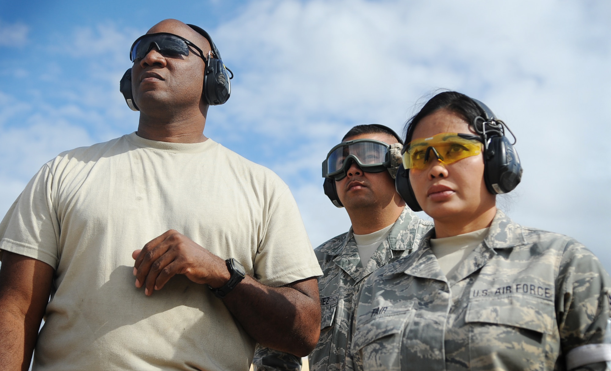 Tech. Sgt. Johan Clay, assigned to the 573rd Global Support Squadron, Tech Sgt. Greg Enriquez and Staff Sgt. Eileen Fair, assigned to the 129th Rescue Wing, look on as a C-130 taxis in at the U.S. Army Combat Support Training Center at Fort Hunter Liggett, Calif. during Exercise Soaring Angel.  Members of the 621st Contingency Response Wing and the 129th Rescue Wing, partnered to get crucial training at the installation’s Schoonover LZ. (U.S. Air Force Photo/MSgt Stan Parker)