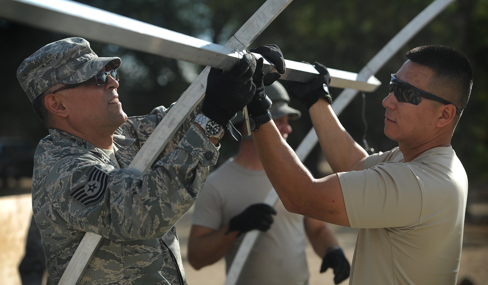 Master Sgt. Mathew Packer (r), assigned to the 573rd Global Support Squadron, receives assistance from Tech Sgt. Gilbert Rodela, assigned to the 146th Airlift Control Flight, Channel Islands, with the construction of an Alaskan small shelter at the U.S. Army Combat Support Training Center at Fort Hunter Liggett, Calif. during Exercise Soaring Angel.  Members of the 621st Contingency Response Wing and the 129th Rescue Wing, partnered to get crucial training at the installation’s Schoonover LZ. (U.S. Air Force Photo/MSgt Stan Parker)