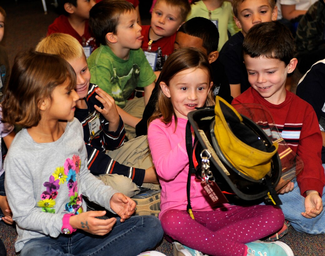 Badger Clark Elementary School students examine a firefighter helmet during a fire prevention presentation in Box Elder, S.D., Oct. 11, 2012. During Fire Prevention Week, firefighters from Ellsworth Air Force Base, S.D., teamed up with area firefighters to explain their jobs and talk about the firefighting equipment they use when combating fires. (U.S. Air Force photo by Airman Ashley J. Woolridge/Released)