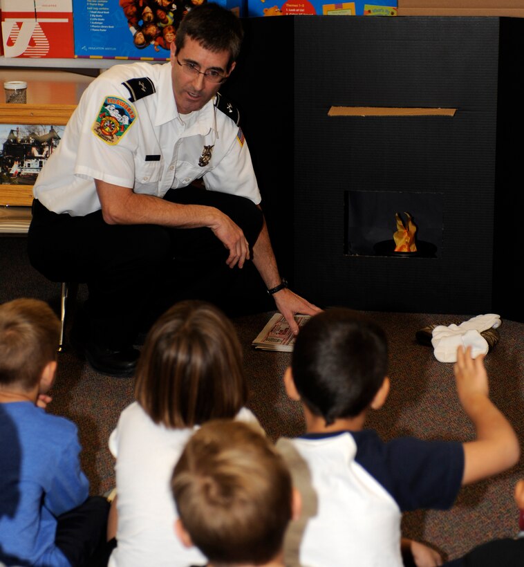 William Beck, 28th Civil Engineer Squadron fire inspector, presents fire safety tips to kindergarten and first grade students during a fire safety program at Badger Clark Elementary School in Box Elder, S.D., Oct. 11, 2012. Beck covered a wide range of information, including keeping flammable objects away from heat sources. (U.S. Air Force photo by Airman Ashley J. Woolridge/Released)