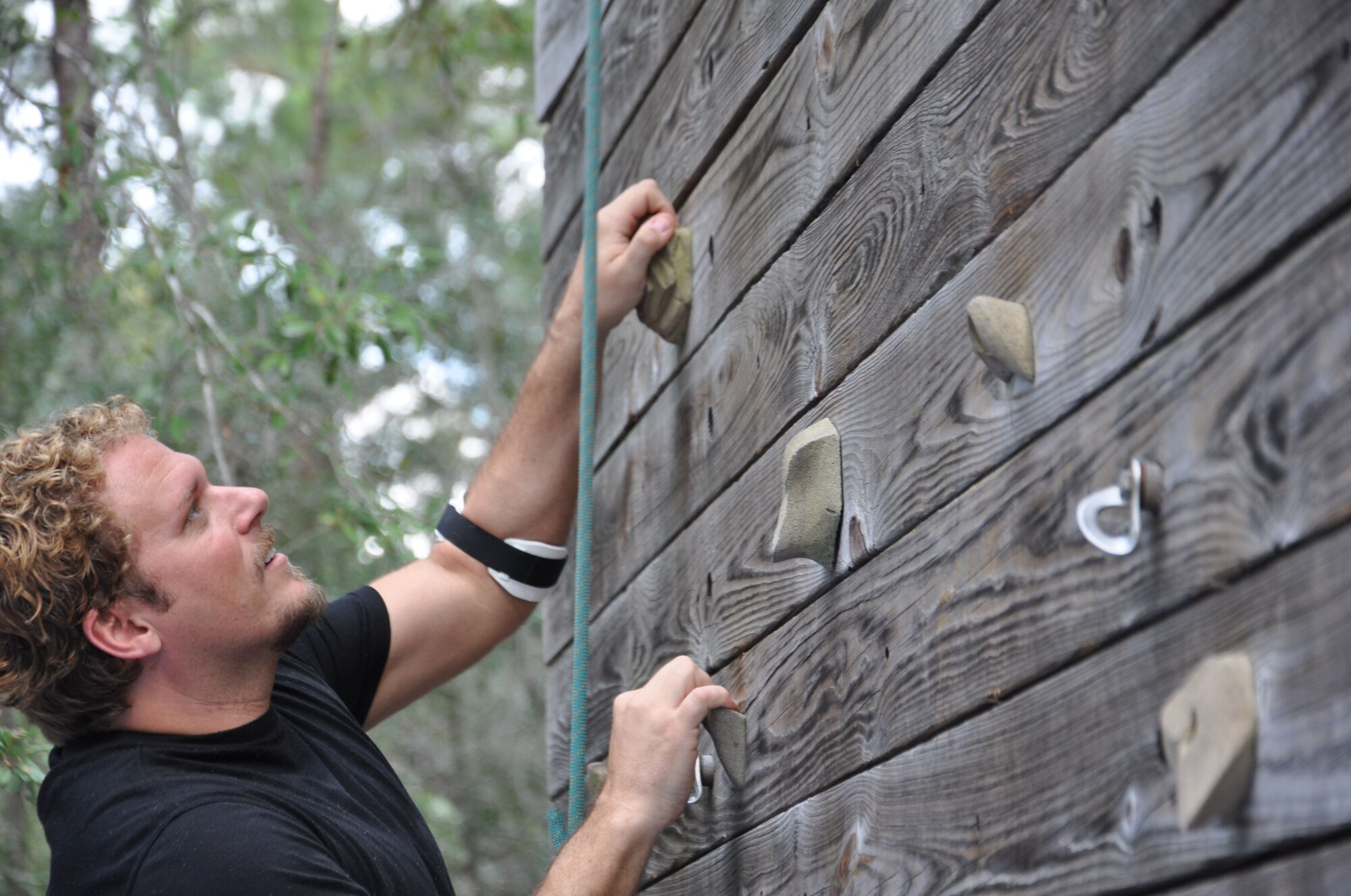 Jeff Carter, a member of Leadership Bay, climbs the 55-foot rock wall at the ropes course on base Oct. 13. Leadership Bay, a subgroup of the Bay County Chamber of Commerce, spent the day completing tasks designed to foster teambuilding. The ropes course is operated by Bonita Bay and run by volunteers. (U.S. Air Force Photo by Ashley M. Wright)