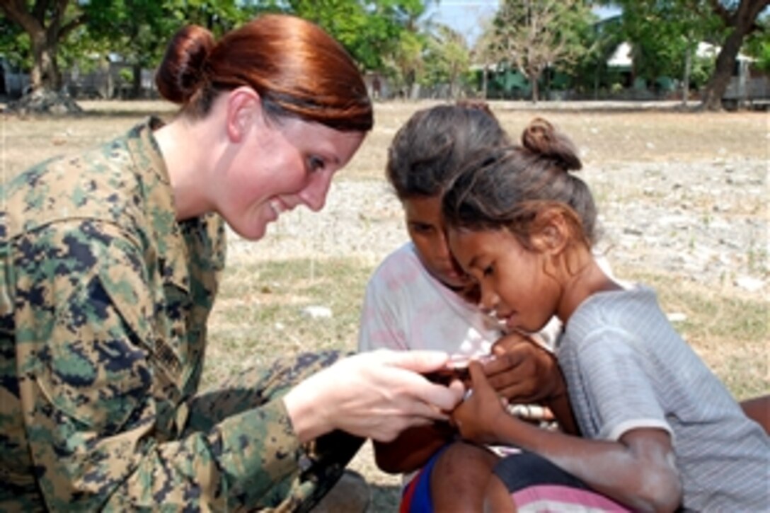 U.S. Marine Corps Cpl. Donika Burkett shares a video on her cell phone with children at Escola Wasco La Gama during a community service day held by amphibious transport dock ship USS Green Bay in Manatutu, Timor-Leste, Oct. 14, 2012. The Green Bay is participating in Exercise Crocodilo 2012, a multilateral exercise that promotes partnership through community service and training with the Timor-Leste Defense Force.