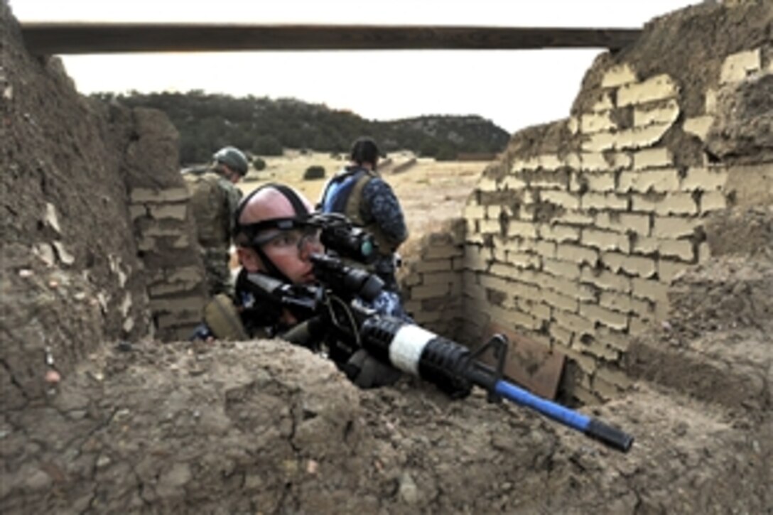 Navy Petty Officer 2nd Class Joshua Allen takes cover during a simulated ambush on Fort Carson, Colo., Oct. 10, 2012. 