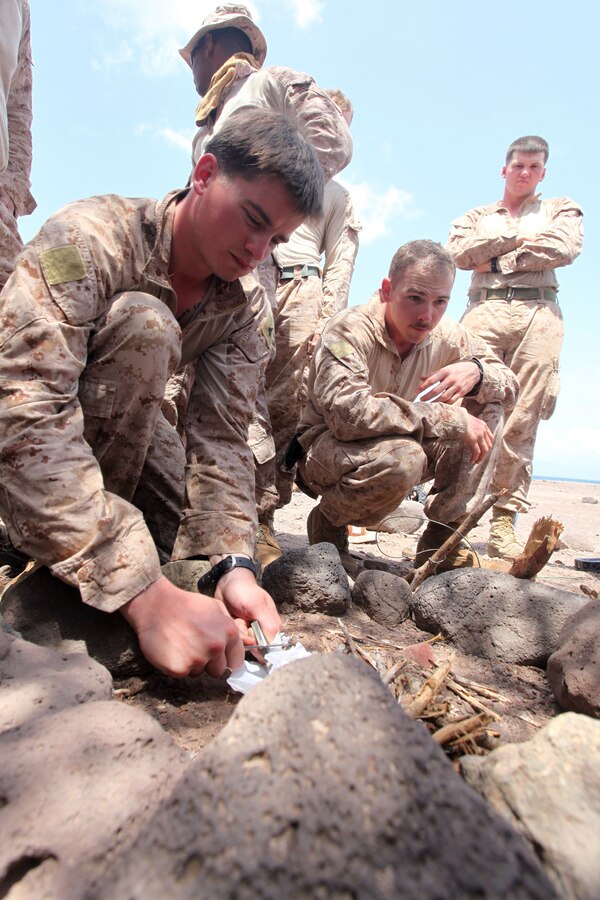 (DJIBOUTI, Sept. 30, 2012) - Marines with Bravo Company, Battalion Landing Team 1st Battalion, 2nd Marine Regiment, 24th Marine Expeditionary Unit, attempt to light a campfire during a desert survival training course in Djibouti, Sept. 30, 2012. The training was part of a three-week exercise comprising basic infantry skills and desert survival techniques. The 24th MEU is deployed with the Iwo Jima Amphibious Ready Group as a theater reserve and crisis response force in U.S. Central Command and the Navy's 5th Fleet area of responsibility. (Photo by Staff Sgt. Robert L. Fisher III)