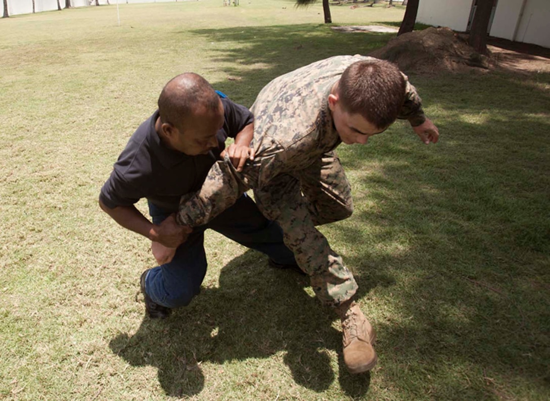 An embassy guard practices compliance techniques on Cpl. Justin Dryer, military police detachment, Combat Logistics Battalion, 15th Marine Expeditionary Unit, at the embassy in Dili, Timor Leste Oct 13. The MEU and the Peleliu Amphibious Ready Group were on the island conducting Exercise Crocodilo 12 to promote interoperability and cooperation between the participating forces, providing the opportunity to exchange knowledge and learn from each other, as well as to establish personal and professional relationships. Marines and sailors of the 15th MEU and the Peleliu Amphibious Ready Group are conducting military training with the Timor-Leste Defense Forces and assisting in humanitarian efforts to improve the medical and dental health of the local population.  Sanchez, 23 is from Colorado Springs, Co.
