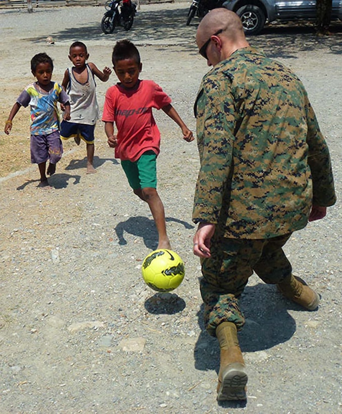 Sgt. Nicholas O. Troyer, data chief, Battalion Landing Team 3/5, 15th Marine Expeditionary Unit, plays soccer with Timorese children after fellow Marines and sailors presented books, school supplies and sporting goods to their elementary school in Manatuto, Timor-Leste, Oct. 14. The donations were part of a community relations program supporting Exercise Crocodilo 2012, a U.S./Timor-Leste event promoting interoperability and regional stability.