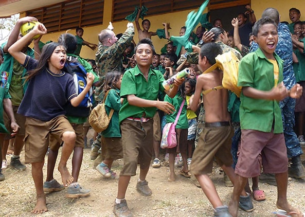 Marines and sailors from the 15th Marine Expeditionary Unit and Peleliu Amphibious Ready Group celebrate the end of a soccer game against Timorese students after they presented books, school supplies and sporting goods to their elementary school in Baucau, Timor-Leste, Oct. 15. The donations were part of a community relations program supporting Exercise Crocodilo 2012, a U.S./Timor-Leste event promoting interoperability and regional stability.