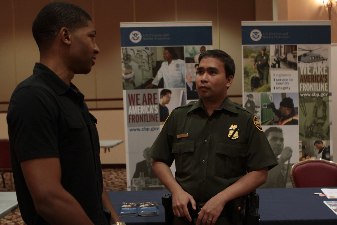 Tarence Wise, left, a military spouse from Piscataway, N.J., talks to Renato Muyot, an agent with U.S. Customs and Border Protection, during a Military Spouse Hiring Fair hosted by the U.S. Chamber of Commerce at the Pacific Views Event Center here Oct. 11.