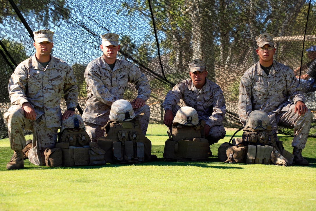 Marines from Second Battalion, Fourth Marine Regiment, Fox Company, take a group photograph with a static display of flak jackets and Kevlar helmets during the Commanding General’s 1st Invitational Golf Tournament at Camp Pendleton’s Marine Memorial Golf Course, Oct. 15. 