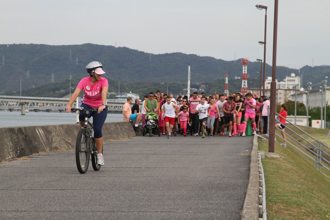Andrea Aguirre, Marine Corps Community Service health promotions director, leads the pack of The Race to Save Second Base Five-Kilometer Fun Run participants on the seawall here Oct. 13, 2012. The event offered participants the opportunity to learn about detection of early stages of breast cancer. 