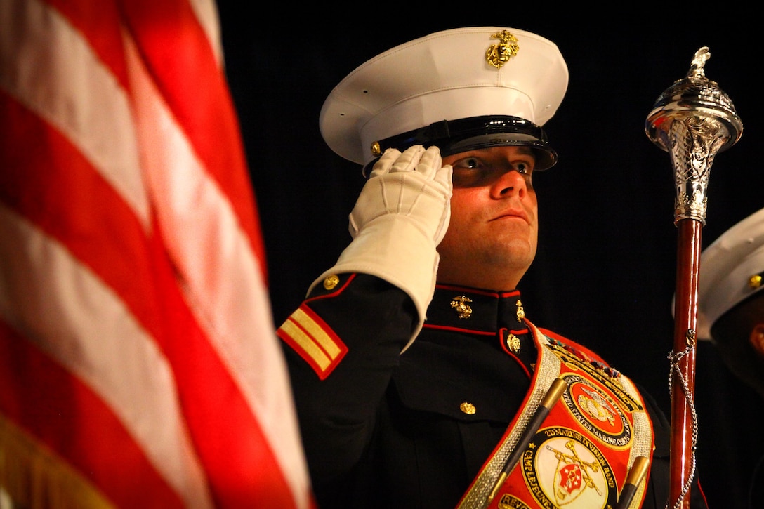 Staff Sgt. Steven Williams, a trumpet player with the 2nd Marine Division Band, salutes during the playing of the national anthem at a local high school. Williams will be taking on the challenge of leading the Marine musicians as the assistant drum major for The President’s Own. 