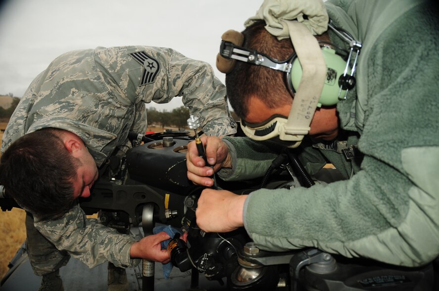 Senior Airman Leonard Tran, a helicopter maintainer assigned to the 129th Aircraft Maintenance Squadron, services the damper on an HH-60G Pave Hawk rescue helicopter during Soaring Angel 13-1 at Fort Hunter Liggett, Calif., Oct 12, 2012. A damper is a piece of equipment that puts stress on the blade of a helicopter and allows the blade to move side to side while conducting routine maintenance. Soaring Angel 13-1 is a collaborative tactical training exercise hosted by the 129th Rescue Wing designed to demonstrate the wing’s rescue and deployable capabilities and interoperability with joint forces. (Air National Guard photo by Staff Sgt. Kim E. Ramirez)

