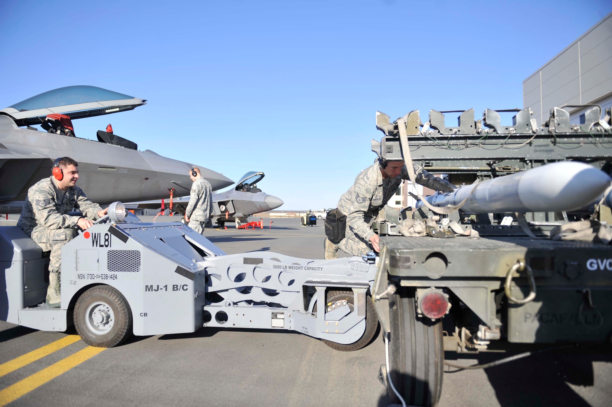 JOINT BASE ELMENDORF-RICHARDSON, Alaska -- Air Force Staff Sgt. Adam Ducharme, 477th Aircraft Maintenance Squadron load crew member, operates an MJ-1 lift truck to transport a practice missile onto an F-22 Raptor aircraft during the annual load competition Oct. 17. The load competition is an event held to demonstrate the skill level and knowledge of all Joint Base Elmendorf-Richardson aircraft maintainers including active-duty and Reserve Airmen. (U.S. Air Force photo/ Airman Ty-Rico Lea)