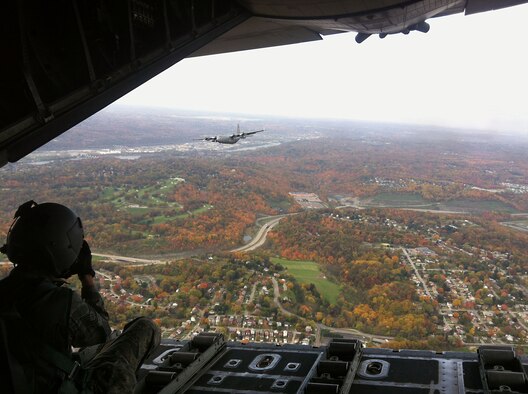 Tech Sgt. Christine Jones, a photographer from the 4th Combat Camera squadron, March Air Reserve Base, Calif., is harnessed onto an open ramp of a 911th Airlift Wing C-130 H2 during a formation flight training exercise Oct. 18, 2012.  Jones’ first-time aerial photography training included shooting still photos from the C-130s ramp and ‘troop’ or side doors, while the unit's 758th Airlift Squadron aircrew members trained on a variety of tactics to include; two-ship formations, run-ins, and low-level routes. The Fall foliage created a picturesque backdrop, which further added to the uniqueness of Jones' first-time Southwestern Pa. experience. In addition to aerial photography training, Jones also captured images of the 911th Airlift Wing's annual barrier and anti-terrorism exercise, which was held earlier in the week. The mission of Combat Camera (COMCAM) is to acquire still and motion imagery in support of classified and unclassified air, sea, and ground military operations. (U.S. Air Force photo by Senior Airman David Vanik, 758th Airlift Squadron)