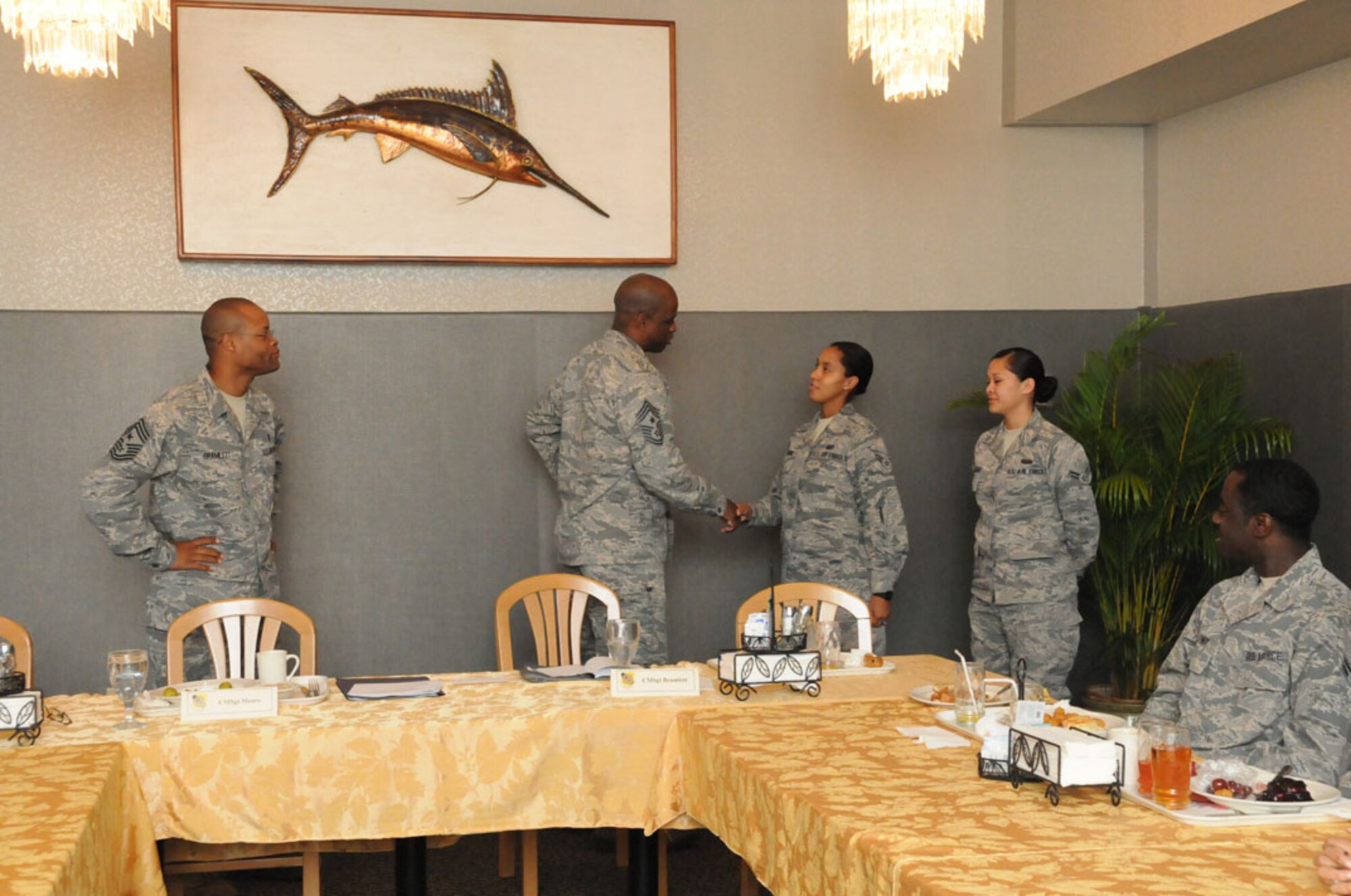 Chief Master Sgt. Jerry Moore, 11th Air Force command chief from Joint Base Elmendorf-Richardson, Alaska, presents his coin to Airman 1st Class Kasheka Codner, 647th Contracting Squadron, Hawaii after having breakfast with Airmen Oct. 16 at the Hale A'ina Dining Facility on Joint Base Pearl Harbor-Hickam, Hawaii. (U.S. Navy photo by David D. Underwood, Jr.)