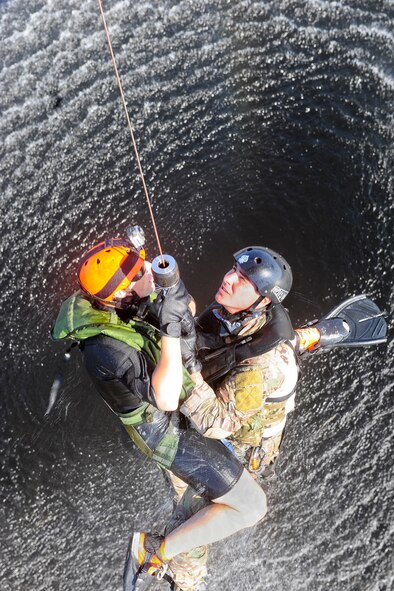 U.S. Air Force Staff Sgts. Alejandro Cerrano and Justin Tyler, 38th Rescue Squadron pararescuemen, hold a winch line during water operations training in the Gulf of Mexico, Oct. 11, 2012. The training allowed Cerrano and Tyler to practice various methods of recovering victims stranded in water. (U.S. Air Force photo by Staff Sgt. Joshua J. Garcia/Released)  