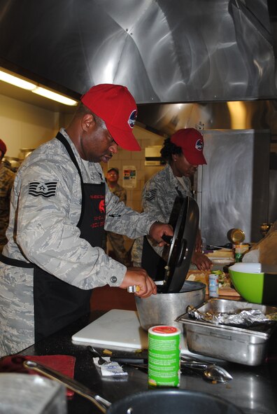 Tech. Sgt. Darnell Samuel, 819th RED HORSE Squadron NCO in charge of material control, and his teammate, Tech. Sgt. Cinnamon Calloway-Fuller, 819th RHS member, sauté onions as they prepare their signature dish of grilled butter spice chicken with pumpkin, mash potatoes and green beans. (U.S. Air Force photo/Airman 1st Class Katrina Heikkinen)