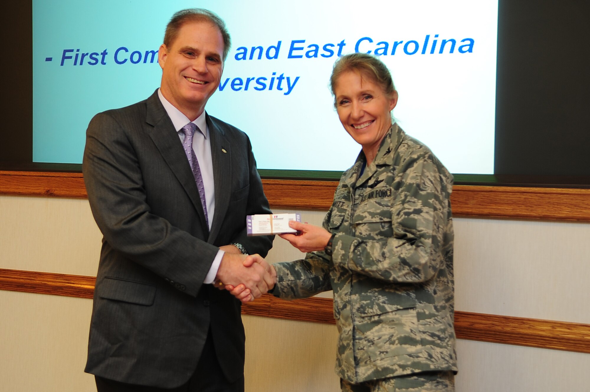 Pete Whelan, First Command local district advisor, presents football game tickets to U.S. Air Force Col. Jeannie Leavitt, 4th Fighter Wing commander, during a meeting on Seymour Johnson Air Force Base, N.C., Oct. 16, 2012. Members of Team Seymour were invited to attend the East Carolina University Military Appreciation Day football game against the U.S. Naval Academy on Oct. 27. (U.S. Air Force photo/Airman 1st Class Aubrey White/Released)