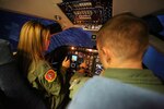Capt. Cory Henwood, 99th Flying Training Squadron T-1A Jayhawk instructor training pilot, demonstrates to his wife, Rebekah Henwood, what it is like to fly in a simulator, during the 99th FTS Annual Spouse Appreciation day Oct 5. at Joint Base San Antonio-Randolph. Spouses who attended learned about their partner’s and other squadron members roles in the Air Force mission. (U.S. Air Force photo by Josh Rodriguez)