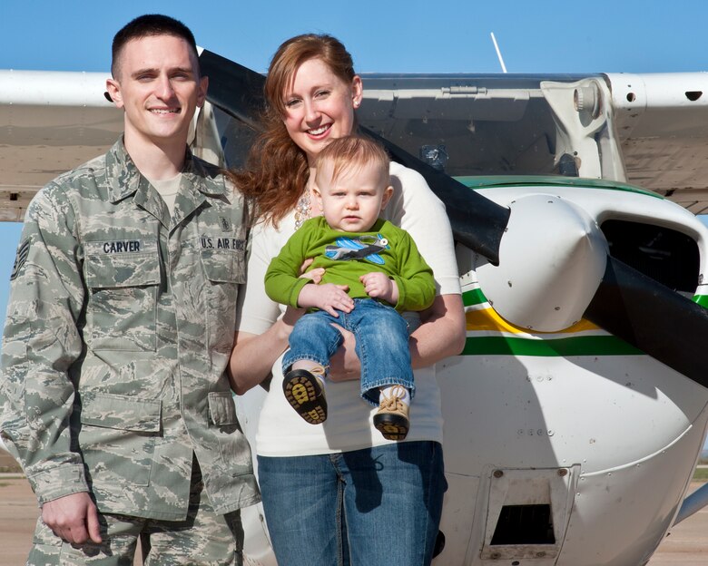 ALTUS, Okla. -- Staff Sgt. Nicholas Carver, 97th Medical Support Squadron NCO in charge of central appointments and patient travel, his wife Sarah and son, Skylar, pose for a photo in front of a Cessna 172 Skyhawk aircraft at the Altus/Quartz Mountain Regional Airport Oct. 18, 2012. Carver was recently selected to attend Officer Training School and is scheduled to attend Undergraduate Pilot Training afterwards. (U.S. Air Force photo by Senior Airman Kenneth W. Norman / Released)