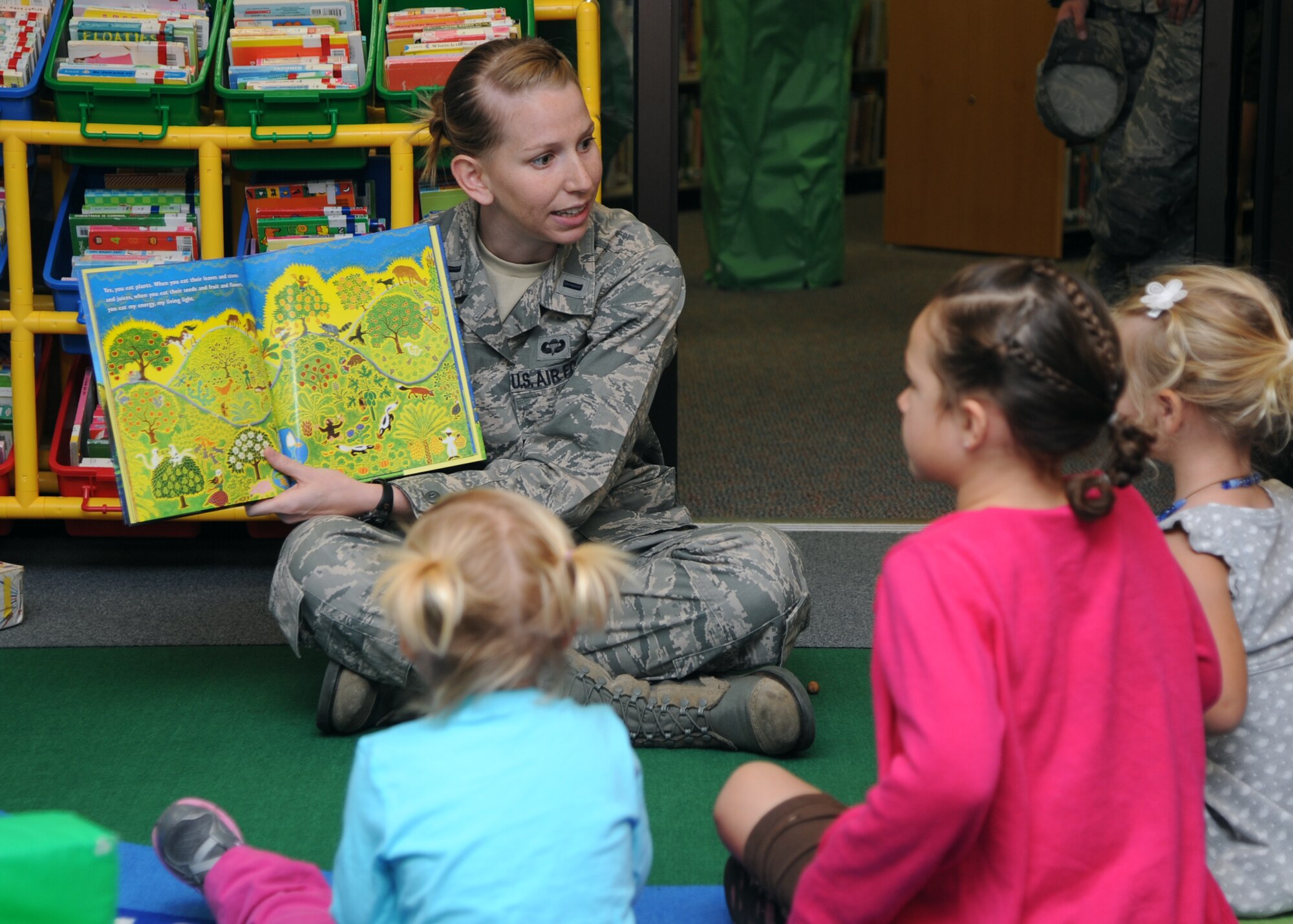 ALTUS AIR FORCE BASE, Okla. – 1st Lt. Lauren Sahagun, 97th Civil Engineer Squadron energy manager, reads a book about energy generated by sunlight to children at the base library to celebrate Energy Action Month, Oct. 18, 2012. Sahagun organized various activities to take place on base throughout the month of October to educate children and adults about the importance of saving energy. (U.S. Air Force photo by Airman 1st Class Klynne Pearl Serrano / Released)