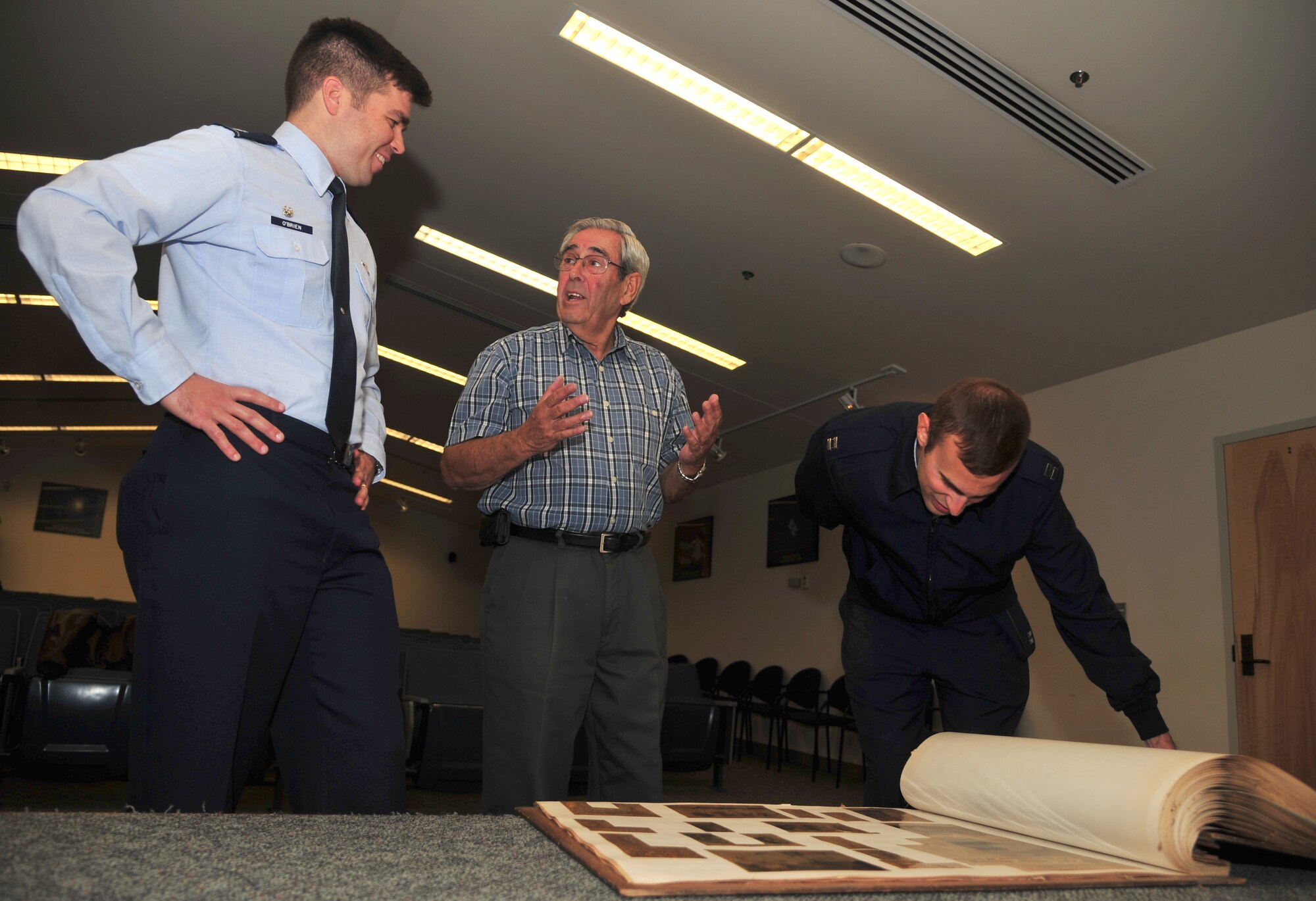 Retired Lt. Col. Al Kessler talks with Lt. Col. Patrick O'Brien about his time as a KC-135 Stratotanker pilot while Capt. Chris Smith looks through the 93rd Air Refueling Squadron’s heritage book, Oct. 15, 2012. Kessler gifted the scrapbook to his former unit while visiting the current squadron commander, Lt. Col. Patrick O’Brien. The book features articles and photos dating back to 1963. O'Brien is the current 93rd ARS commander and Smith is the squadron’s executive officer. (U.S. Air Force photo by Airman 1st Class Earlanadez Young)       