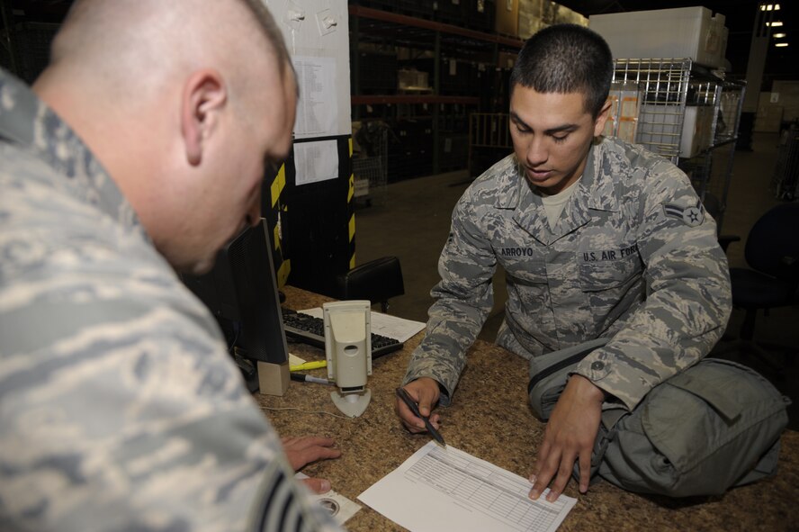Airman 1st Class Emmanuel Arroyo, 509th Logistics Readiness Squadrons individual protective equipment technician, issues an M-50 gasmask to Staff Sgt. Joe Kosal, 509th Maintenance Squadron Aircraft Ground Equipment journeyman, at Whiteman Air Force base, Mo., Oct. 15. Airmen at Whiteman can also find cold weather gear, chemical warfare gear and body armor and helmets at the IPE desk. (U.S. Air Force photo/Senior Airman Cody H. Ramirez)
