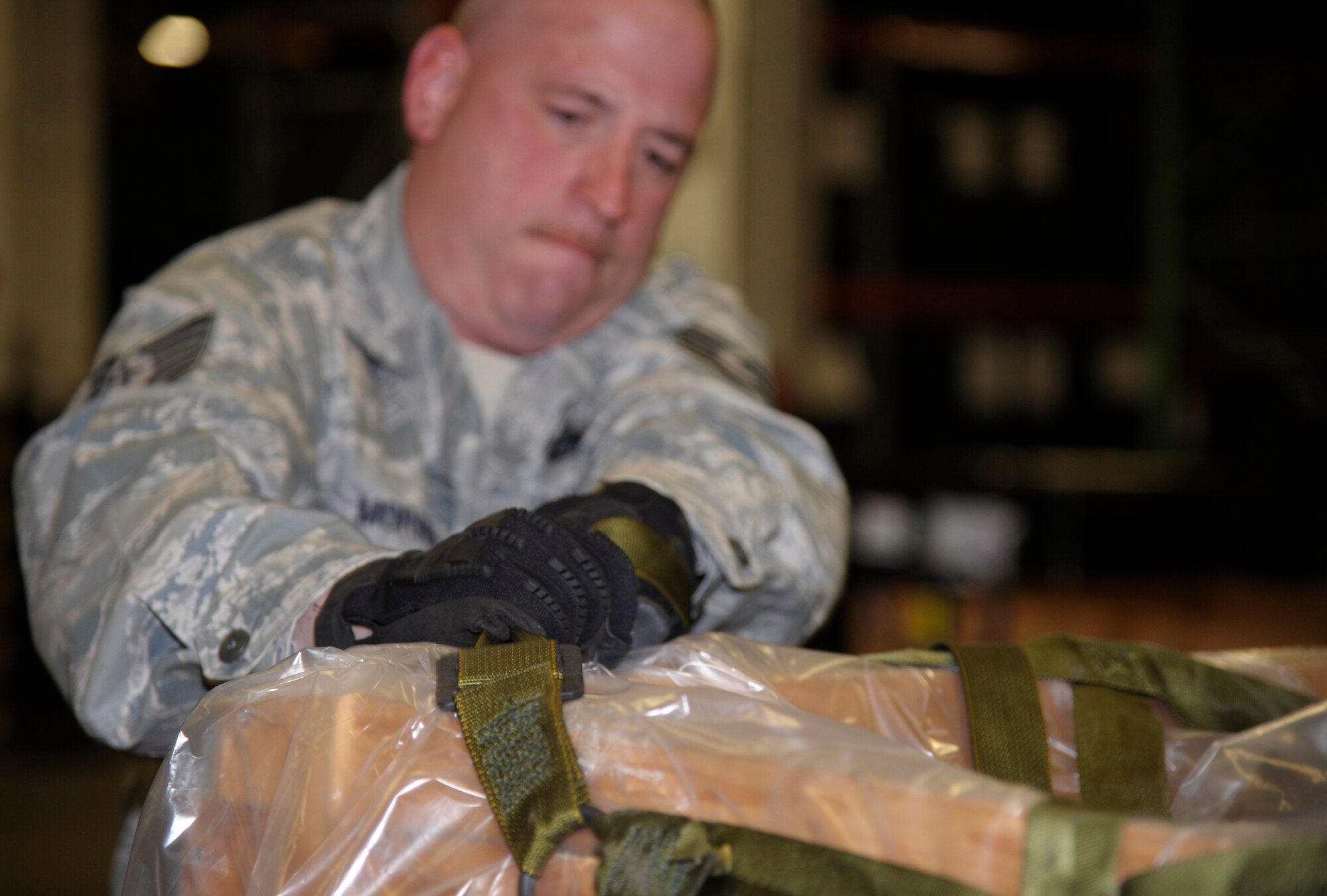 Tech. Sgt. Ronald Morris, 509th Logistics Readiness Squadron NCO in charge of weapons, secures a cargo net around a pallet of B-bags during pre-inspection readiness at Whiteman Air Force Base, Mo., Oct. 15. Along with B-bags full cold weather gear, the 509th LRS prepared enough C-bags full of chemical gear and body armor and helmets to gear a mass deployment. (U.S. Air Force photo/Senior Airman Cody H. Ramirez)