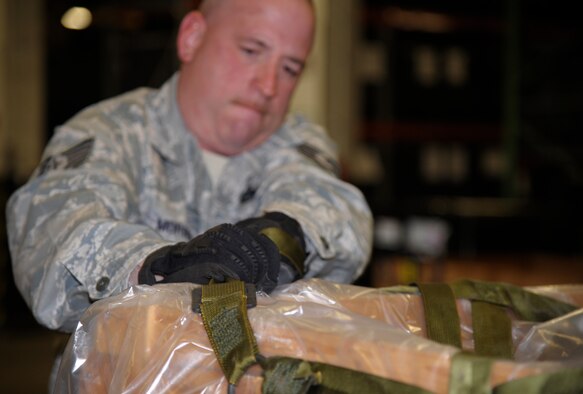 Tech. Sgt. Ronald Morris, 509th Logistics Readiness Squadron NCO in charge of weapons, secures a cargo net around a pallet of B-bags during pre-inspection readiness at Whiteman Air Force Base, Mo., Oct. 15. Along with B-bags full cold weather gear, the 509th LRS prepared enough C-bags full of chemical gear and body armor and helmets to gear a mass deployment. (U.S. Air Force photo/Senior Airman Cody H. Ramirez)