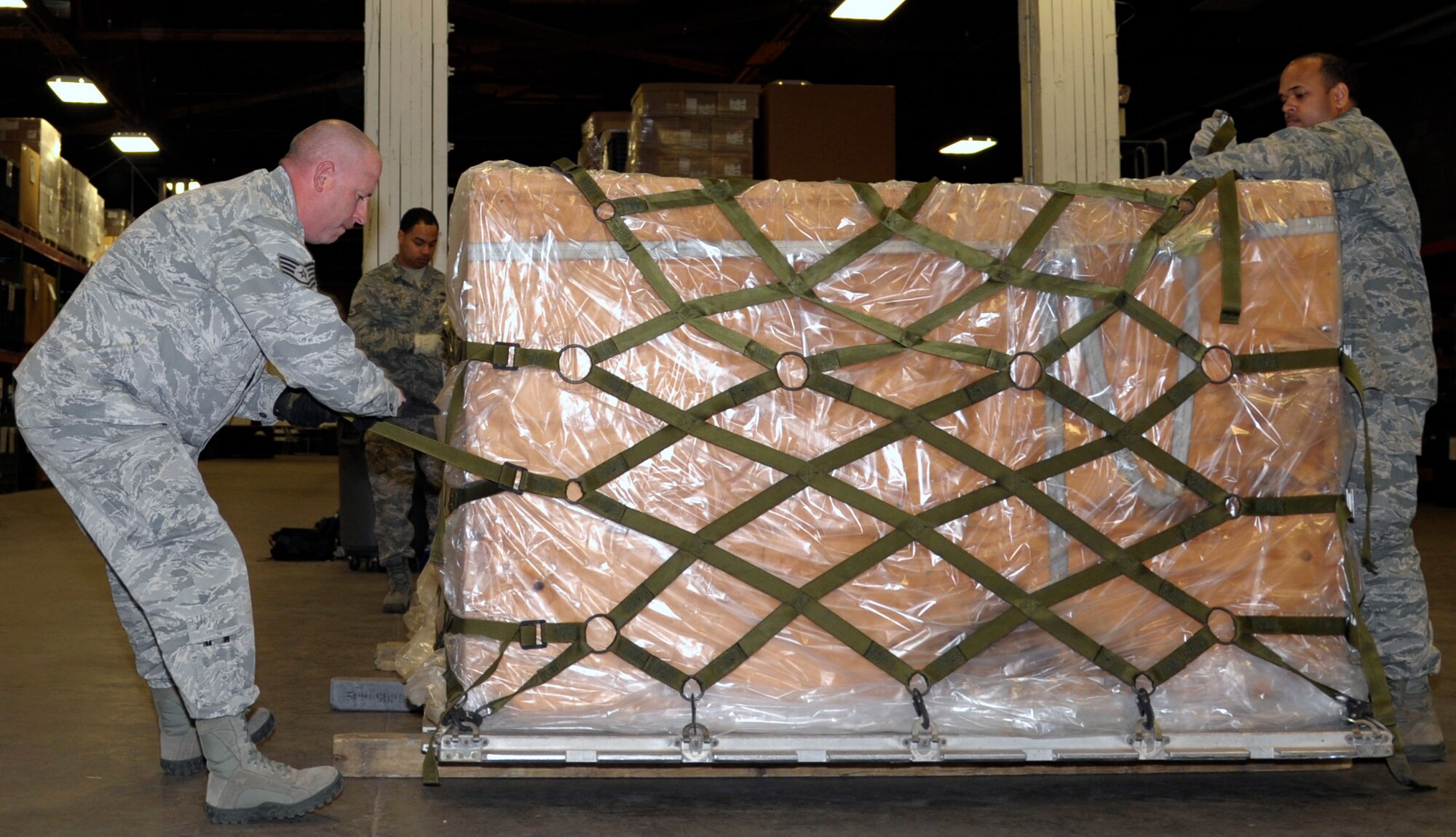 Members of the 509th Logistic Readiness Squadron work together to prepare a pallet full of B-bags containing cold weather gear at Whiteman Air Force Base, Mo., Oct. 15. The preparation was done to support the 509th Bomb Wing in case it has to deploy as a unit at a moment's notice. (U.S. Air Force photo/Senior Airman Cody H. Ramirez)