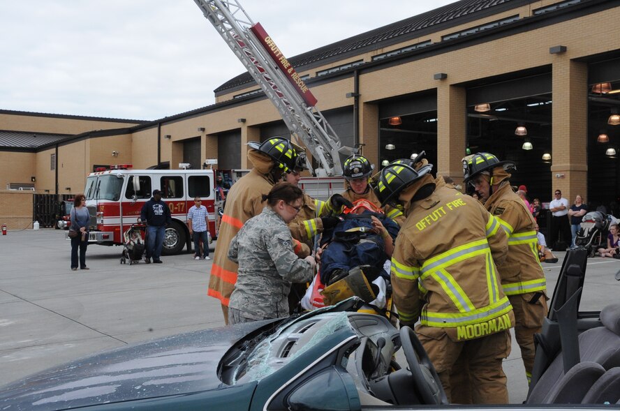 Firefighters and emergency personnel simulate pulling someone out of a badly wrecked car during the Fire Prevention Week Open House at the Offutt Air Force Base Fire Station Oct. 13. Offutt's Fire Department teamed up with the National Fire Protection Association during Fire Prevention Week, Oct. 7-13, to urge residents to "Have Two Ways Out!" (U.S. Air Force photo by Kendra Williams/Released)