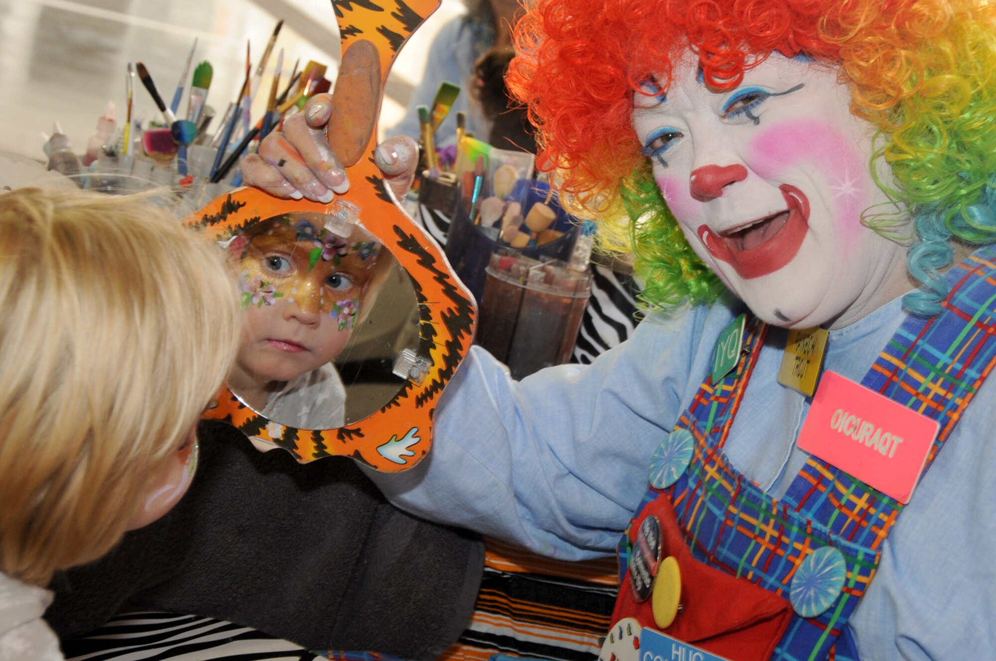 Allison Kelling, daughter of Tech. Sgt. Ryan Kelling, looks in the mirror after having her face painted during the Fire Prevention Week Open House at the Offutt Air Force Base Fire Station Oct. 13. The Offutt Fire Department hosted activities during Fire Prevention Week to promote "Have Two Ways Out!" through educational, family-oriented activities. (U.S. Air Force photo by Kendra Williams/Released)