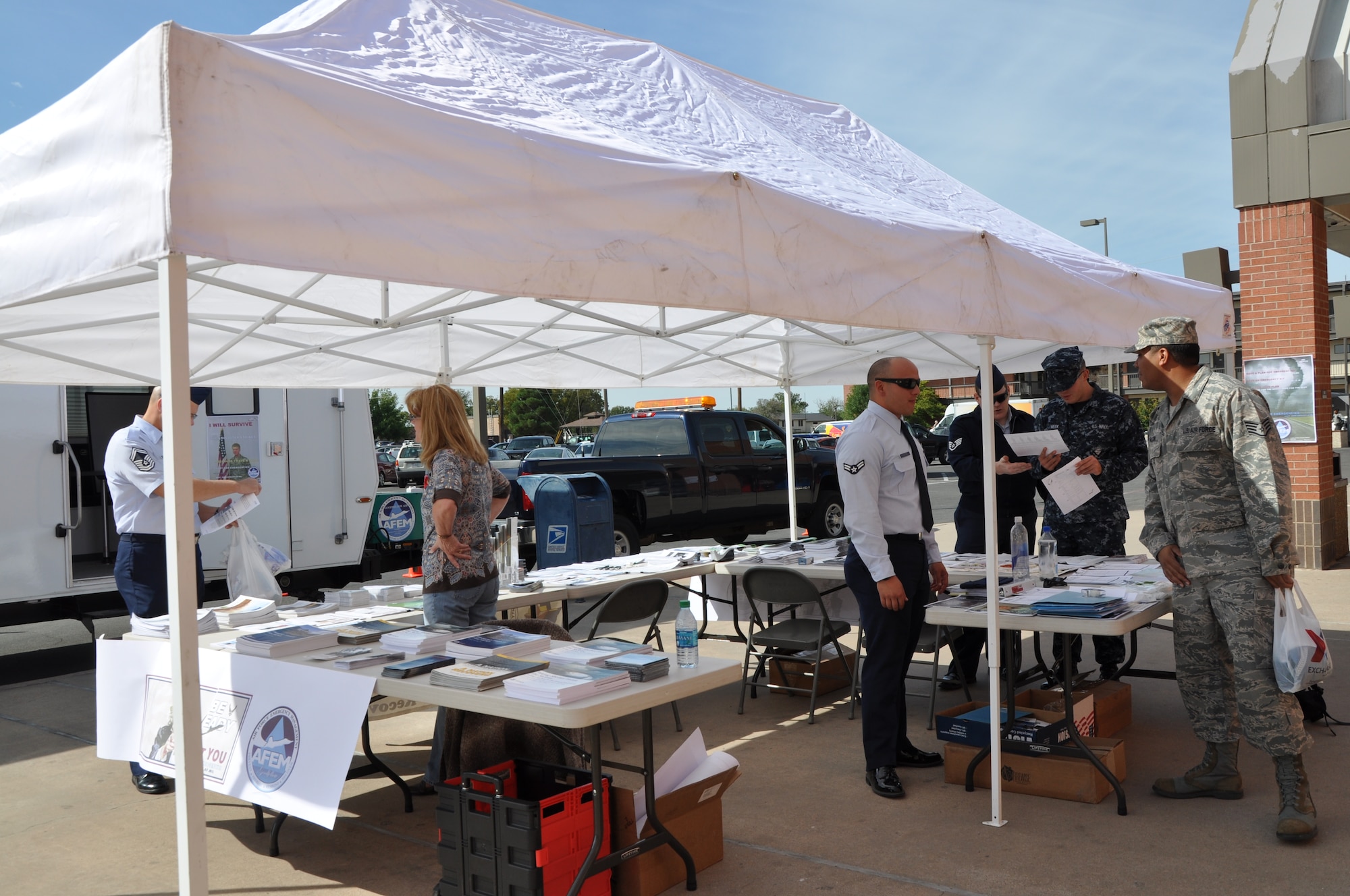 GOODFELLOW AIR FORCE BASE, Texas—Members of the 17th Civil Engineer Squadron pass out pamphlets and guides to raise emergency management awareness Oct. 15 in front of the Base Exchange here. A San Angelo Tom Green County emergency management specialist also helped set up the booth and pass out information. (U.S Air Force photo/Airman 1st Class Jessica Keith)