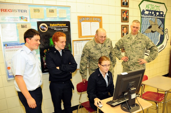 Once again the 107th Airlift Wing steps up. This time it's to mentor our young Junior Reserve Officer Training Corps (JROTC) at the Lewiston-Porter High School. The mission is called CyberPatriot. Brian Boyd, Matt O'Conner, Master Sgt. Joel Micoli and Chief Master Sgt. Mark Grier observed Ashlee Roell performing her cybersecuirty task on Oct, 16, 2012. (U.S. Air Force Photo/Senior Master Sgt. Ray Lloyd)
