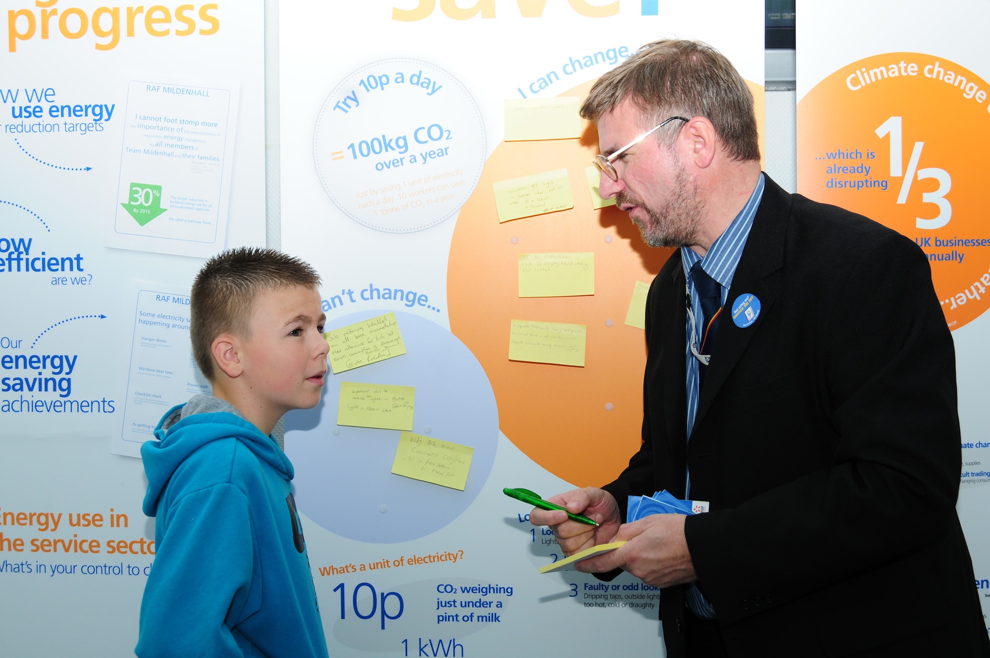 Steve Perry, 100th Civil Engineer Squadron energy manager, talks to Kieran Blanchard, 11, from Essex, about ideas for saving energy at home during the energy awareness roadshow Oct. 18, 2012, at RAF Mildenhall. October is Energy Awareness Month and in addition to providing energy-saving ideas and giveaways to base personnel, RAF Mildenhall also hosted an energy awareness symposium when members from RAF Mildenhall, RAF Lakenheath and RAF Alconbury got together with energy industry representatives to discuss future opportunities to further energy- and water-saving initiatives. (U.S. Air Force photo by Karen Abeyasekere/Released)
