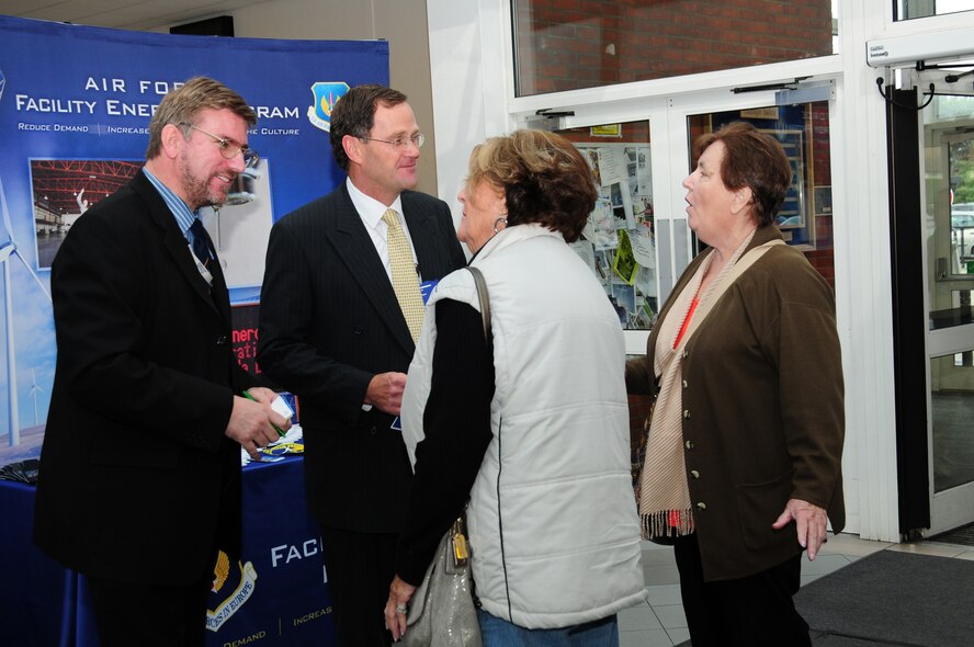 Steve Perry, left, 100th Civil Engineer Squadron energy manager, and Peter Rothery, energy company representative, chat with Daphne Majewski and Grace Stevens, both visiting from the States, about ways to save energy at home, during an energy awareness roadshow Oct. 18, 2012, at RAF Mildenhall, England. Energy suppliers brought information to share with Team Mildenhall members on using microcarbons and reducing carbon-dioxide levels in domestic homes. Suppliers brought information on solar panels, air source heat pumps and solar thermal hot water. RAF Mildenhall’s energy manager also chatted with people about their own ideas on ways to save energy. (U.S. Air Force photo by Karen Abeyasekere/Released)