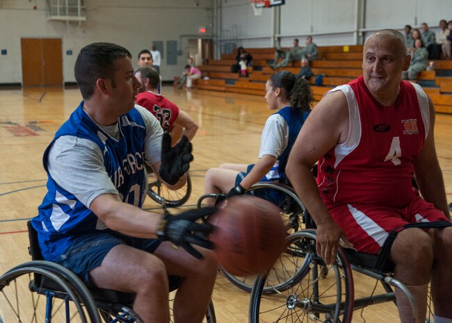 Tech. Sgt. Kenneth Shockley, 628th Civil Engineer Squadron (left) passes the ball to a teammate around opponent Senad Cerovic during a wheelchair basketball game against the North Charleston Rolling Hurricanes Oct. 17, 2012, at Joint Base Charleston - Air Base. The North Charleston Rolling Hurricanes are a wheelchair basketball team sponsored by the Achieving Wheelchair Equality. AWE is dedicated to encouraging people with mobility impairments to participate in recreational activities. (U.S. Air Force photo/Airman 1st Class Ashlee Galloway)