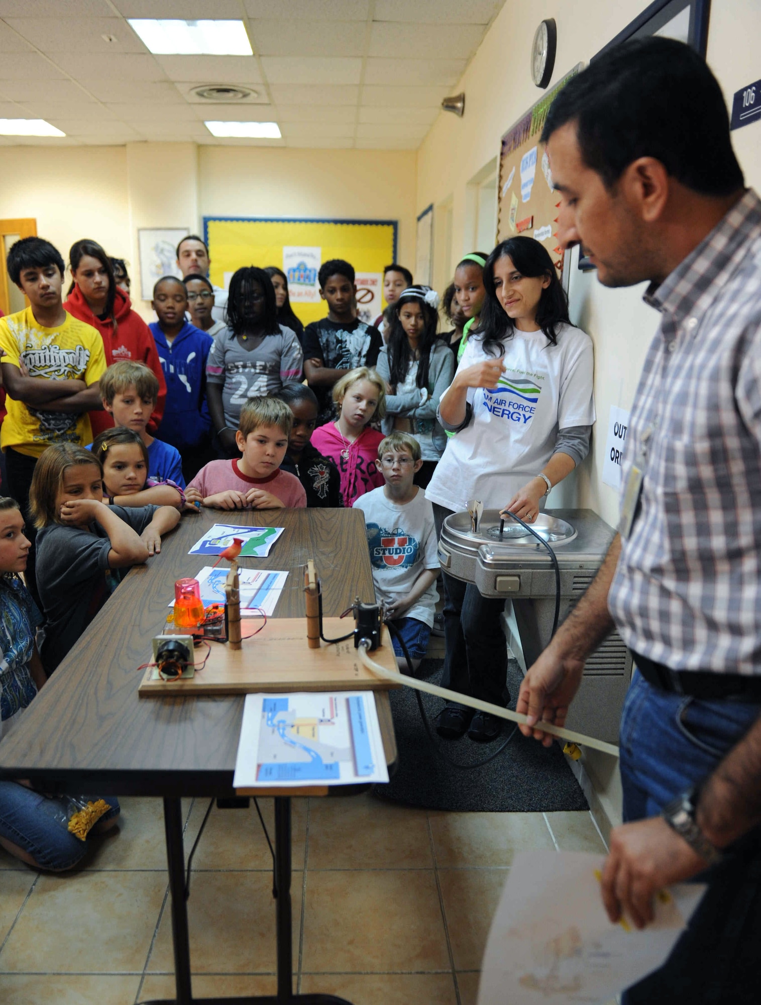 A contractor with the 39th Civil Engineer Squadron, right, demonstrates to middle-school students how a hydro-electric generator works Oct. 16, 2012, at the Incirlik Unit School, Incirlik Air Base, Turkey. Students learned how water could be harnessed to create electricity. (U.S. Air Force photo by Senior Airman Anthony Sanchelli/Released)

