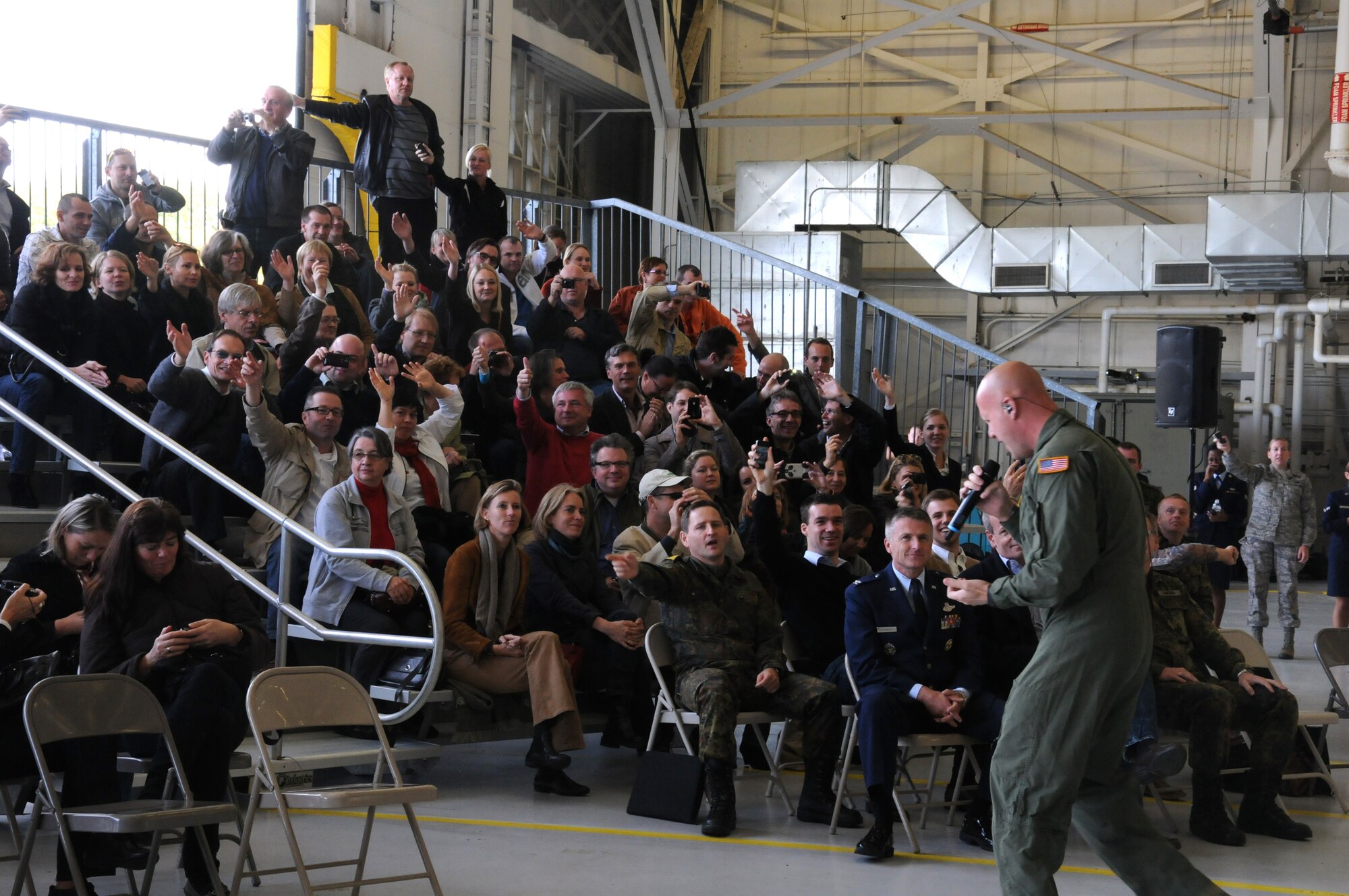 U.S. Air Force Master Sgt. Ryan Carson, a vocalist for The U.S. Air Force Band Max Impact, sings to a group of people from the Embassy of the Federal Republic of Germany, Washington D.C., during a performance in Hangar 10 of the 459th Air Refueling Wing, Joint Base Andrews, Md., Oct. 17. The visit included a base tour, demonstrations from the 11th Wing Security Force’s working dog team, The U.S. Air Force Honor Guard Drill Team, The U.S. Air Force Band Max Impact and aircraft displays from the 459th ARW, 1st Helicopter Squadron and the 113th Wing. The German Embassy goes out into the community each year and their visits rotate between the different branches of the embassy. This year, the embassy's military branch had the distinct privilege of hosting. (U.S. Air Force photo/ Senior Airman Katie Spencer)