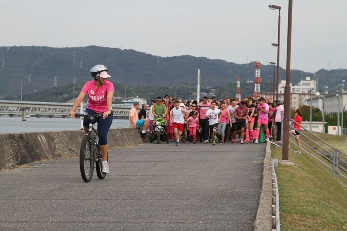 Andrea Aguirre, Marine Corps Community Service health promotions director, leads the pack of The Race to Save Second Base Five-Kilometer Fun Run participants on the seawall here Oct. 13, 2012. The event offered participants the opportunity to learn about detection of early stages of breast cancer.