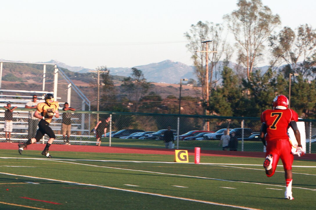 Wide receiver Luke Boyd, 1, with 1st Marine Logistics Group Beast, catches a 60-yard touchdown pass from quarterback Matthew Petree against the 11th Marine Regiment Cannon Cockers at the 11-Area football field at Marine Corps Base Camp Pendleton, Calif., Oct. 15. The Beast defeated the Cannon Cockers 34-28 and secured the number one seed in the playoffs.