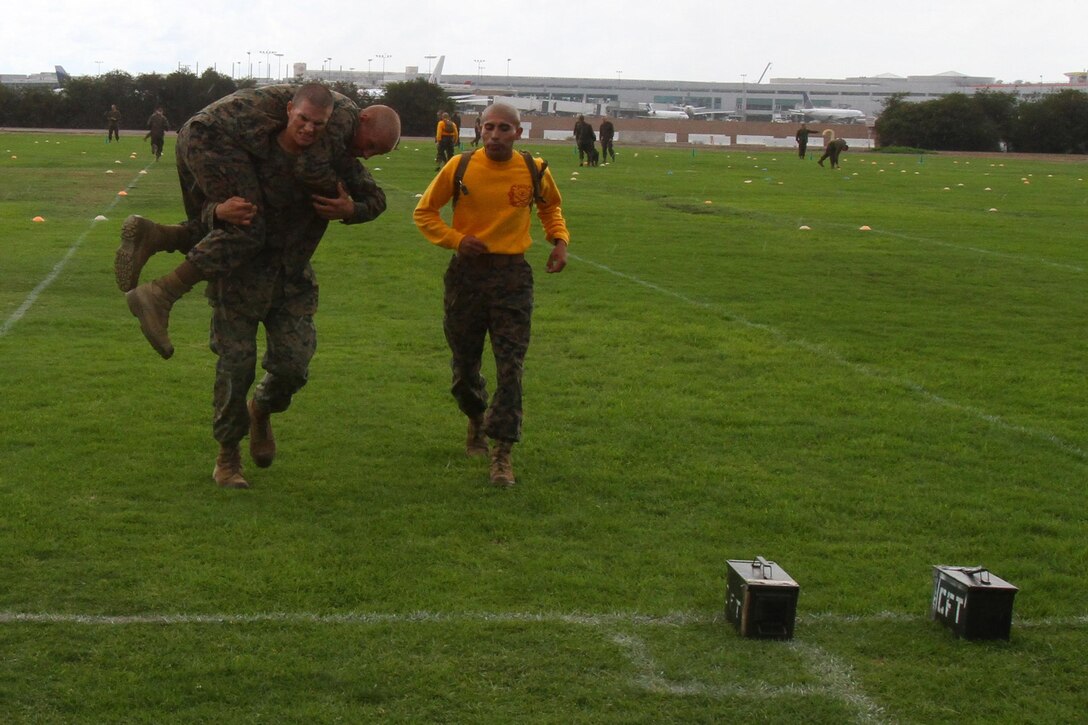 A recruit of Company G, 2nd Recruit Training Battalion, fireman carries another recruit back to the starting line during his Combat Fitness Test aboard Marine Corps Recruit Depot San Diego Oct. 11. The fireman carry is part of the maneuver-under-fire portion of the CFT, right before recruits are instructed to carry two ammunition-cans back and forth down the field.