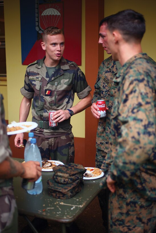 Marines and French Marine paratrooper Lance Cpl. Marvin Lelarge eat lunch together on the first day of Exercise Croix de Sud at Camp la Broche, New Caledonia, Oct. 13. U.S. and French Marines came together for a social prior to beginning bilateral training during Croix du Sud. The Marines are with 1st platoon, Company G. Lelarge is with 8th Marine Infantry Paratrooper Regiment, based out of Castres, France.